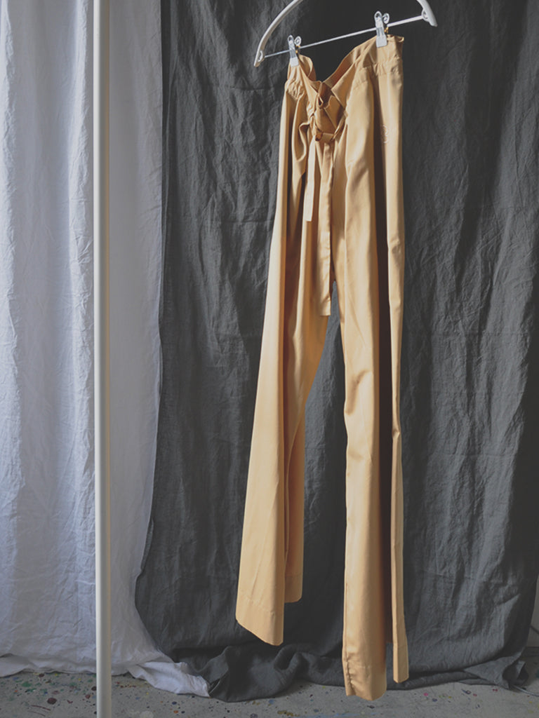 Arona pants hanging on a rack