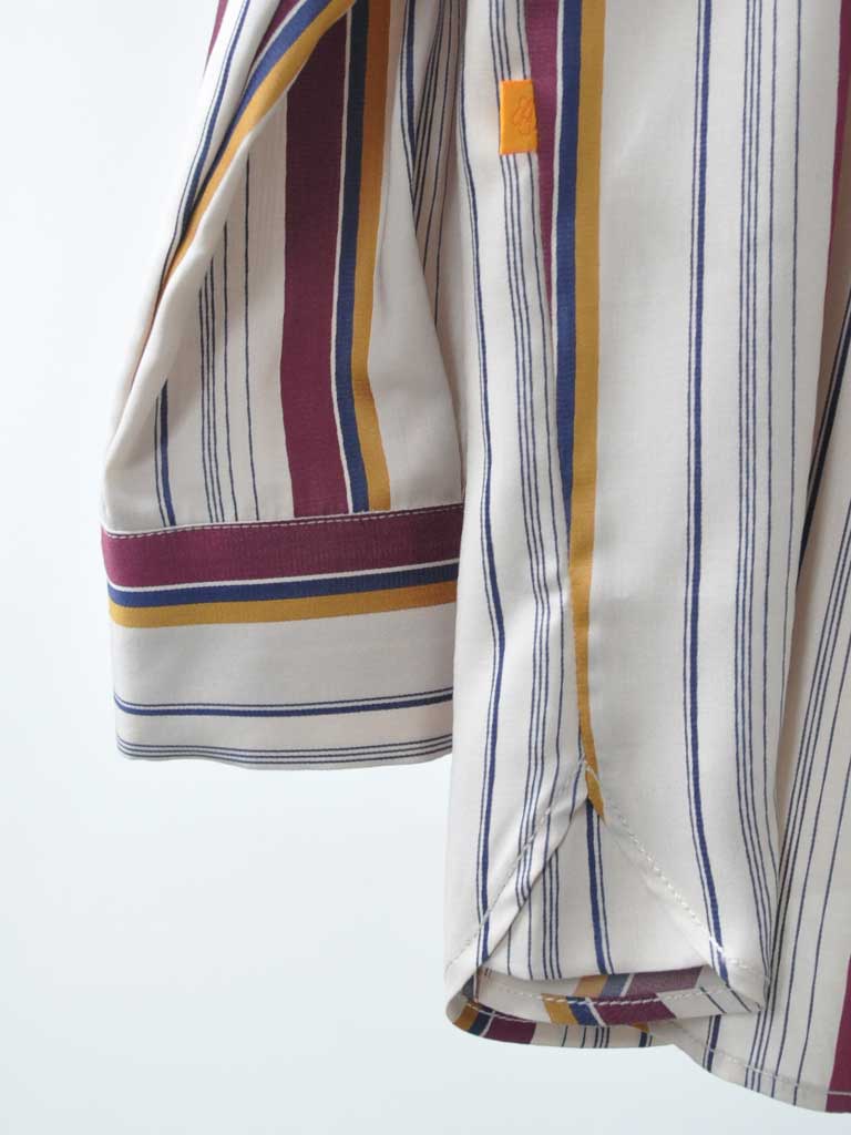 Sideseam Detail Closeup of Ana Sat Shirt in Magenta Stripes on a hanger