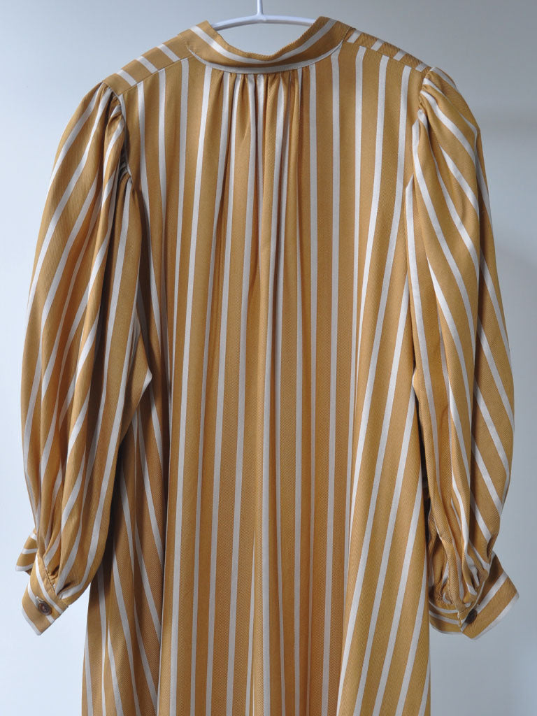 Back of Arona Dress in Ochre Stripes on a hanger