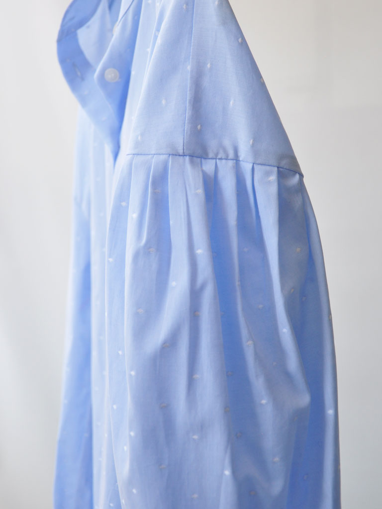 Side Closeup of Aude Shirt in Blue on a hanger