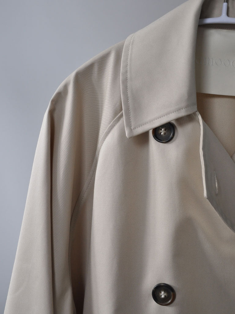 Collar Closeup of Tea Trench Jacket in Beige on a hanger