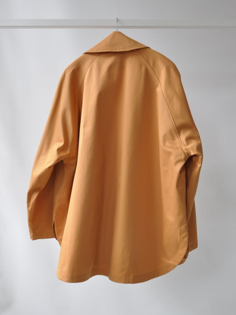 Back of Tea Trench Jacket in Burnt Orange on a hanger