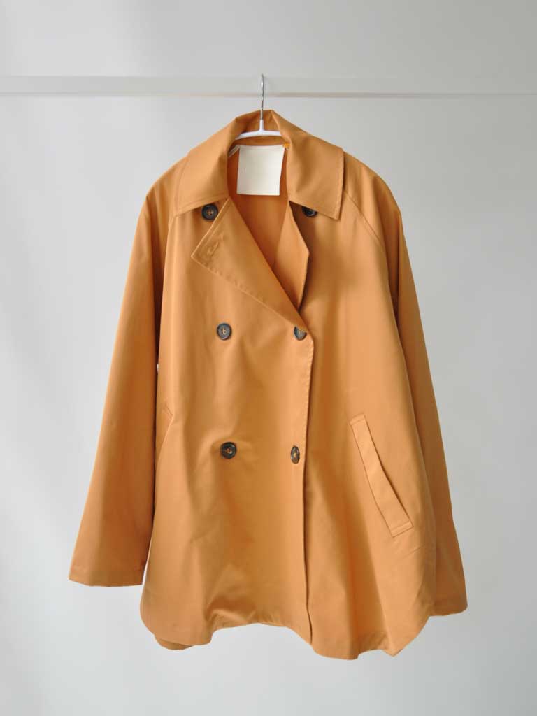 Front of Tea Trench Jacket in Burnt Orange on a hanger
