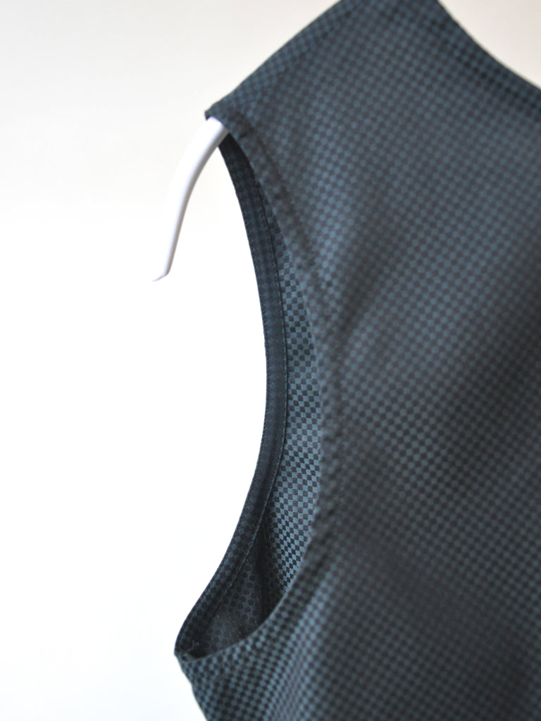 Closeup of Aia top in black and green check