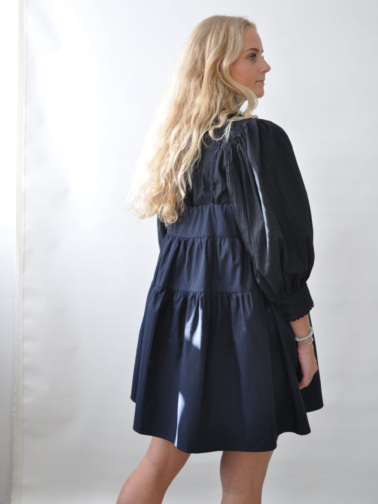 Astis dress in black and purple check over a black shirt